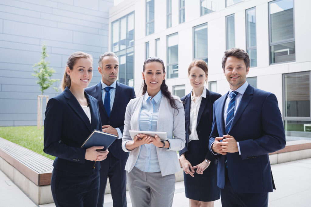 Portrait of confident businesspeople standing outside office building